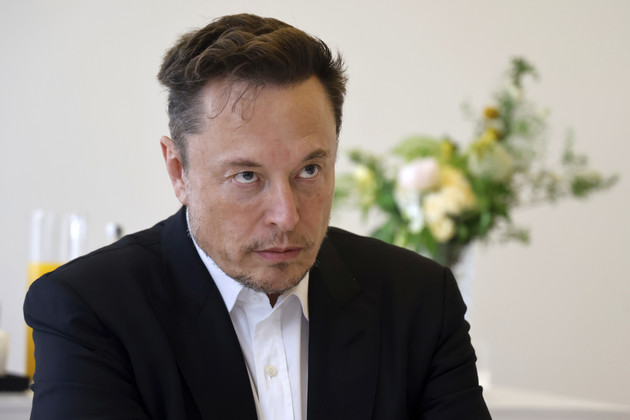 Elon Musk listening during a meeting.